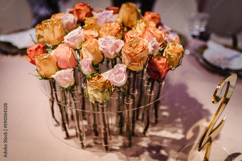 Beautiful decor with floral decorations on wedding ceremony. Festive table newlyweds decorated with composition of flowers and greenery in the banquet hall.