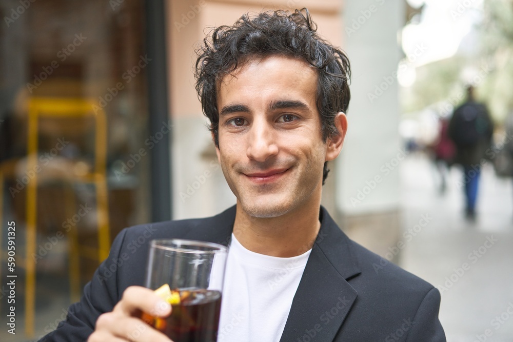 Young businessman enjoying a refreshing cola drink while networking at a sophisticated bar. Young businessman enjoying a refreshing cola drink while networking at a sophisticated bar.