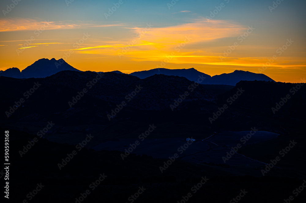 Dark silhouettes of the mountains against the sky at sunset. A typical sunset landscape of the Andalusia, Spain.
