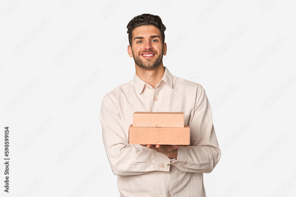 Young man holding a takeaway boxes isolated laughing and having fun. Young man holding a takeaway boxes isolated laughing and having fun.