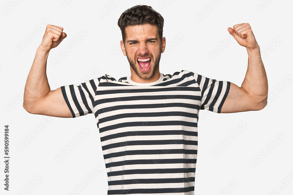 Young handsome man isolated showing strength gesture with arms, symbol of feminine power Young handsome man isolated showing strength gesture with arms, symbol of feminine power