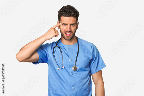 Young nurse man showing a disappointment gesture with forefinger.