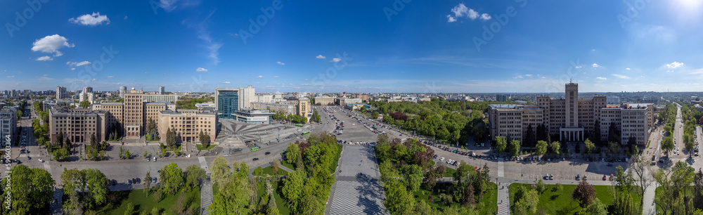 Aerial wide panoramic view on Karazin National University buildings on Freedom Square with spring greenery and blue sunny sky in Kharkiv, Ukraine