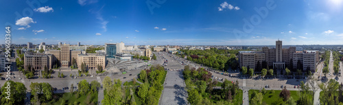Aerial wide panoramic view on Karazin National University buildings on Freedom Square with spring greenery and blue sunny sky in Kharkiv, Ukraine © Kathrine Andi