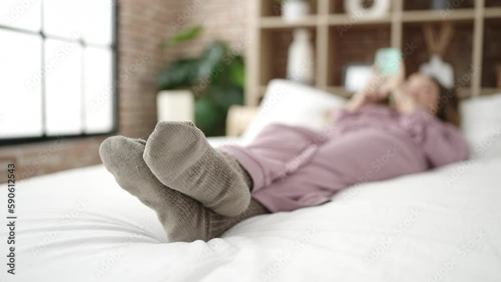 Young beautiful hispanic woman using smartphone lying on bed at bedroom Young beautiful hispanic woman using smartphone lying on bed at bedroom