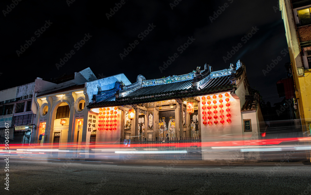 Old Chinese temple architecture at night with long exposure traffic lights
