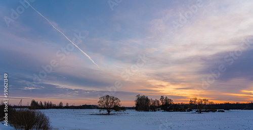 winter evening, sunset and a white line in the sky