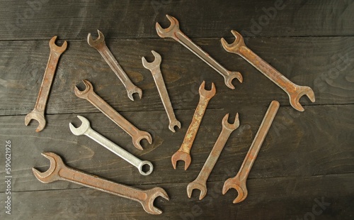 On a wooden background there are many different wrenches, of different sizes. Conceptual construction and hand tools. Flat lay, top view.