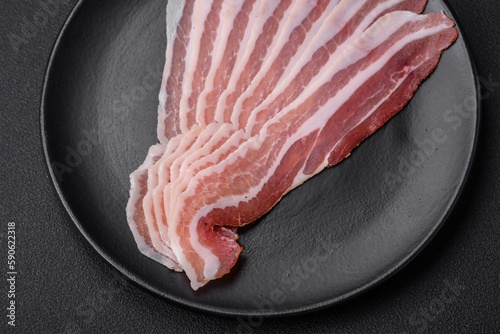 Fotografie Delicious fresh pancetta with salt and spices cut into thin slices