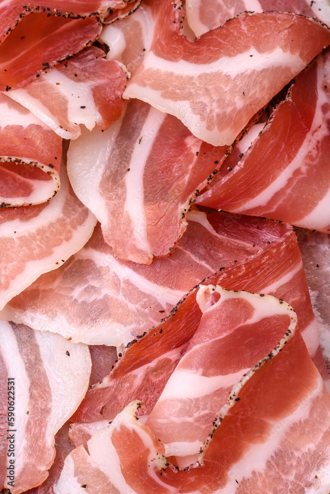 Delicious fresh pancetta with salt and spices cut into thin slices Delicious fresh pancetta with salt and spices cut into thin slices
