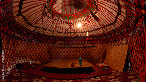 A bulb-lit interior of a yurt at a campsite in the Kyrgyz village of Ozgrush.