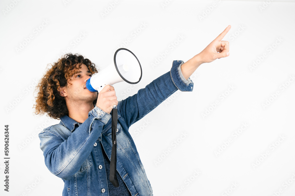 young man holding a megaphone while posing against a white background young man holding a megaphone while posing against a white background