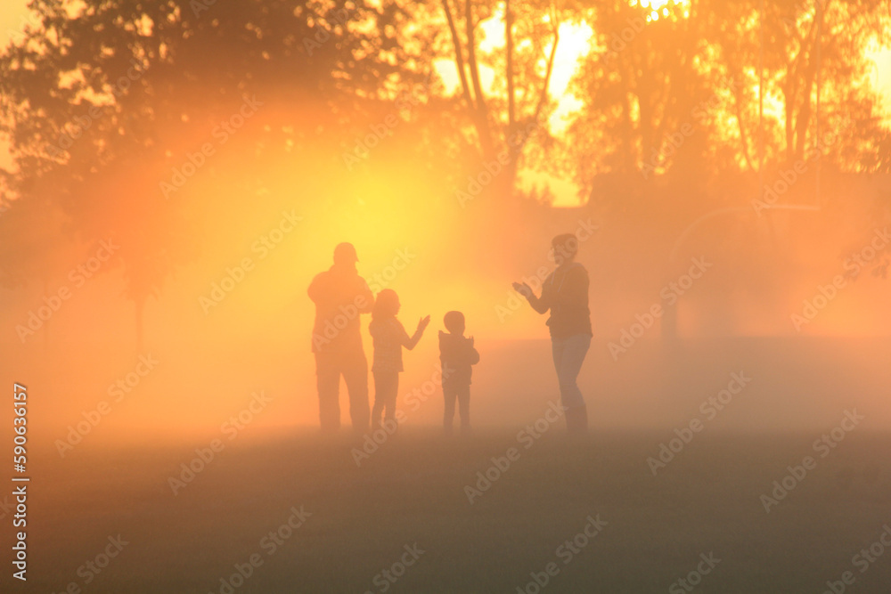 Family playing in the early morning fog