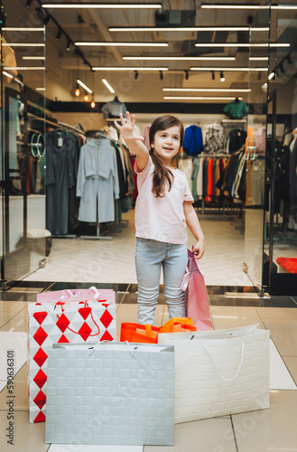 a little girl is shopping in colorful paper bags. child in a clothing store.