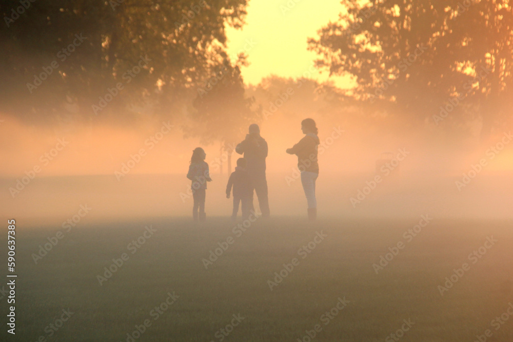 Family playing in the early morning fog Family playing in the early morning fog