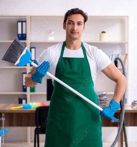 Young handsome contractor cleaning the office