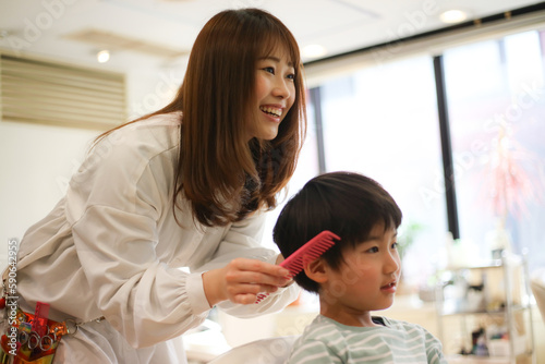 男の子の髪を切る女性美容師