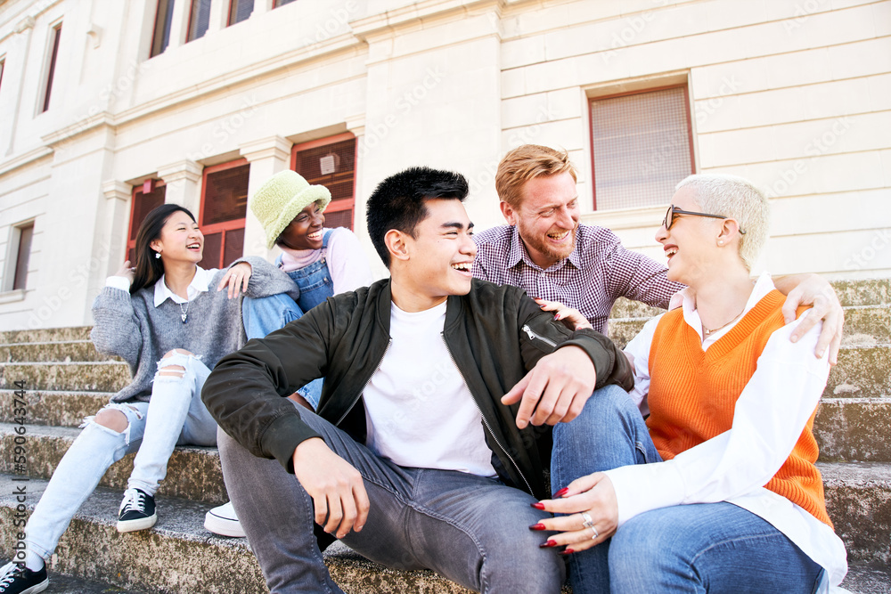 Gathering of multicultural friends on vacation in city. Happy group of multiracial colleagues having fun outdoors and smiling sitting on outside stairs of the museum. People at leisure on spring day. Gathering of multicultural friends on vacation in city. Happy group of multiracial colleagues having fun outdoors and smiling sitting on outside stairs of the museum. People at leisure on spring day.