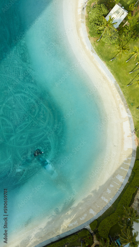 Fototapeta premium Beautiful ocean lagoon overview with white sand and palm trees in Honolulu Hawaii. Aerial drone top-down view.