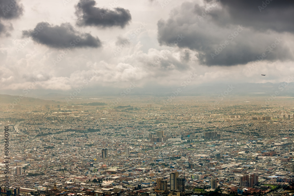 Plane flies over the city of Bogota, Colombia, during a cloudy day Plane flies over the city of Bogota, Colombia, during a cloudy day