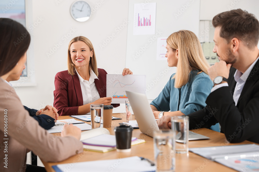 Businesswoman showing chart on meeting in office Businesswoman showing chart on meeting in office