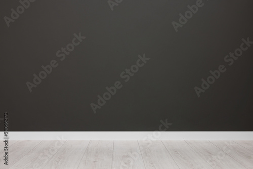 Empty room with black wall and wooden floor