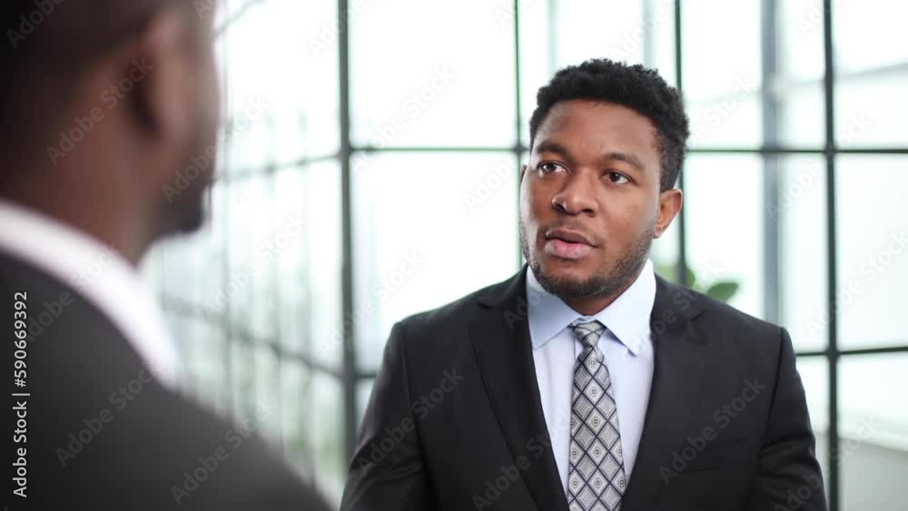 Going over the details. two businessmen talking in the office corridor. Going over the details. two businessmen talking in the office corridor.