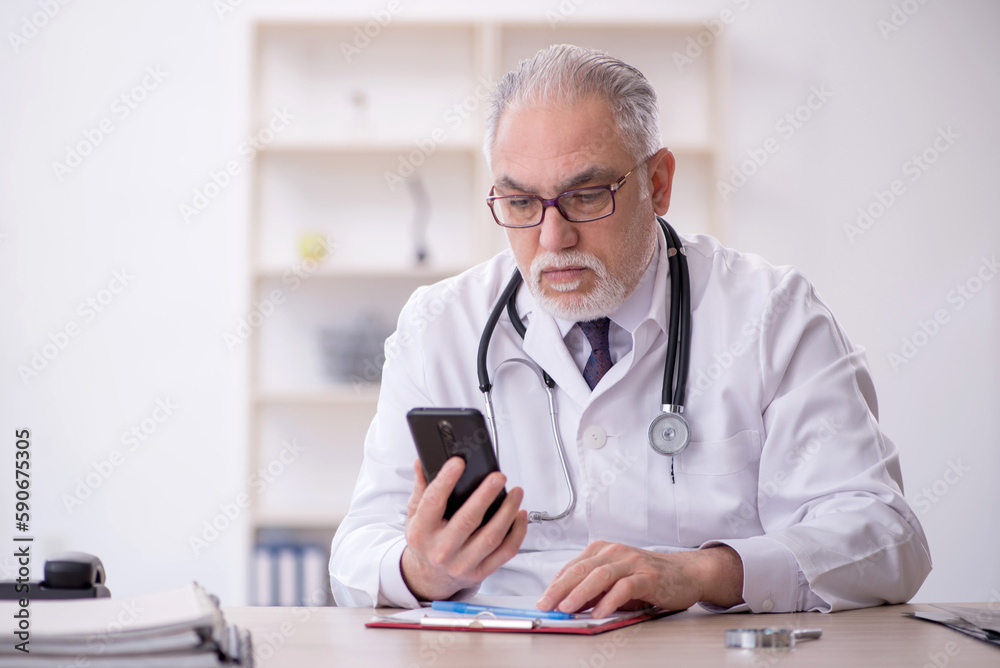 Old male doctor in telemedicine concept Old male doctor in telemedicine concept