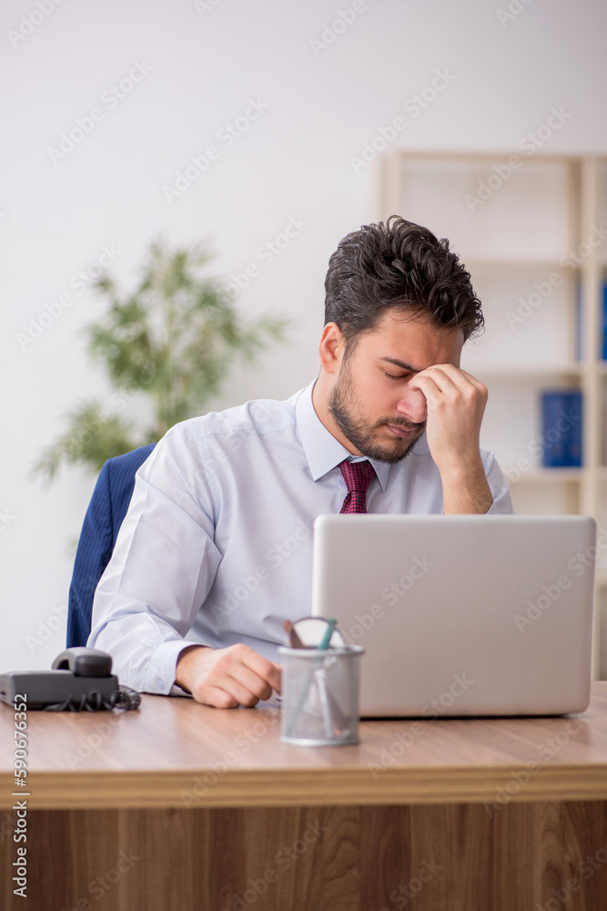 Young male employee working in the office Young male employee working in the office
