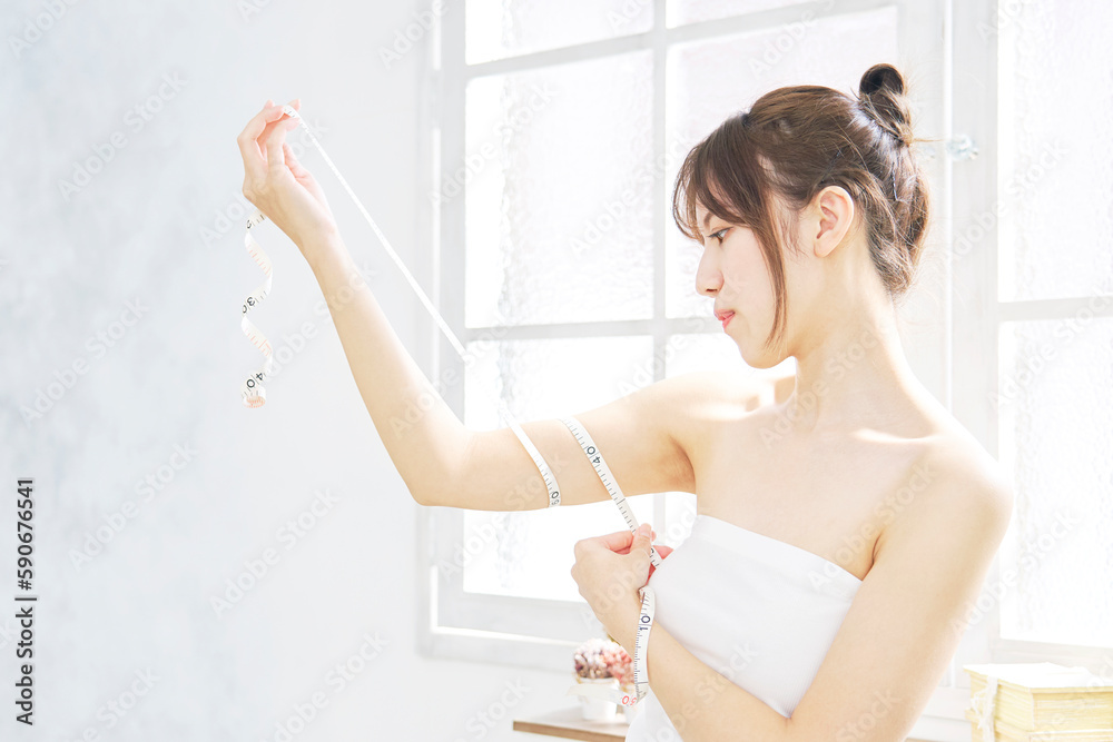 ダイエットイメージ　二の腕にメジャーを巻く女性
