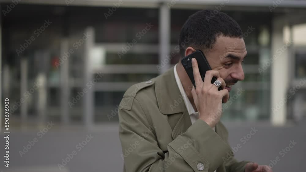 One Arab man talking on phone receiving unbelievable news. A happy Middle Eastern reacting to conversation on smartphone One Arab man talking on phone receiving unbelievable news. A happy Middle Eastern reacting to conversation on smartphone
