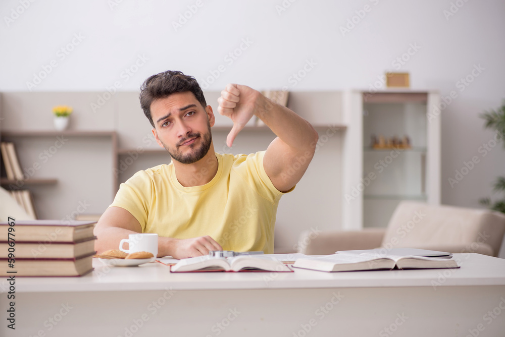 Obraz premium Young male student studying at home