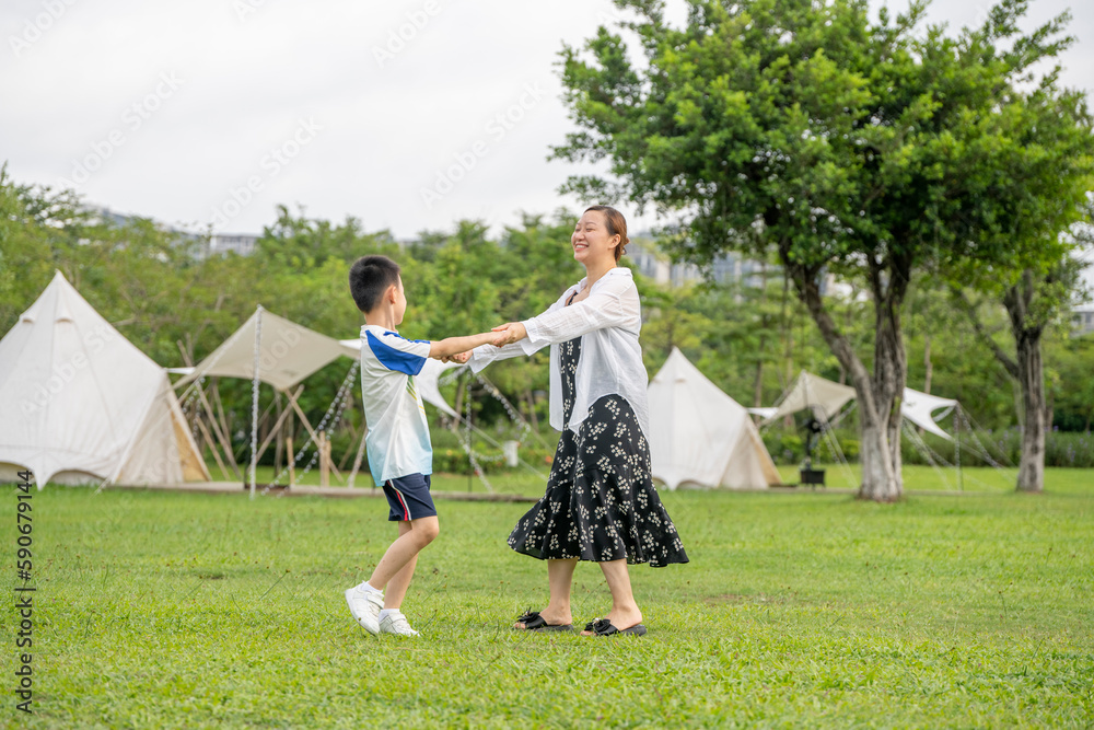Moms and Children Playing on the Camping Grassland in the Summer Park Moms and Children Playing on the Camping Grassland in the Summer Park