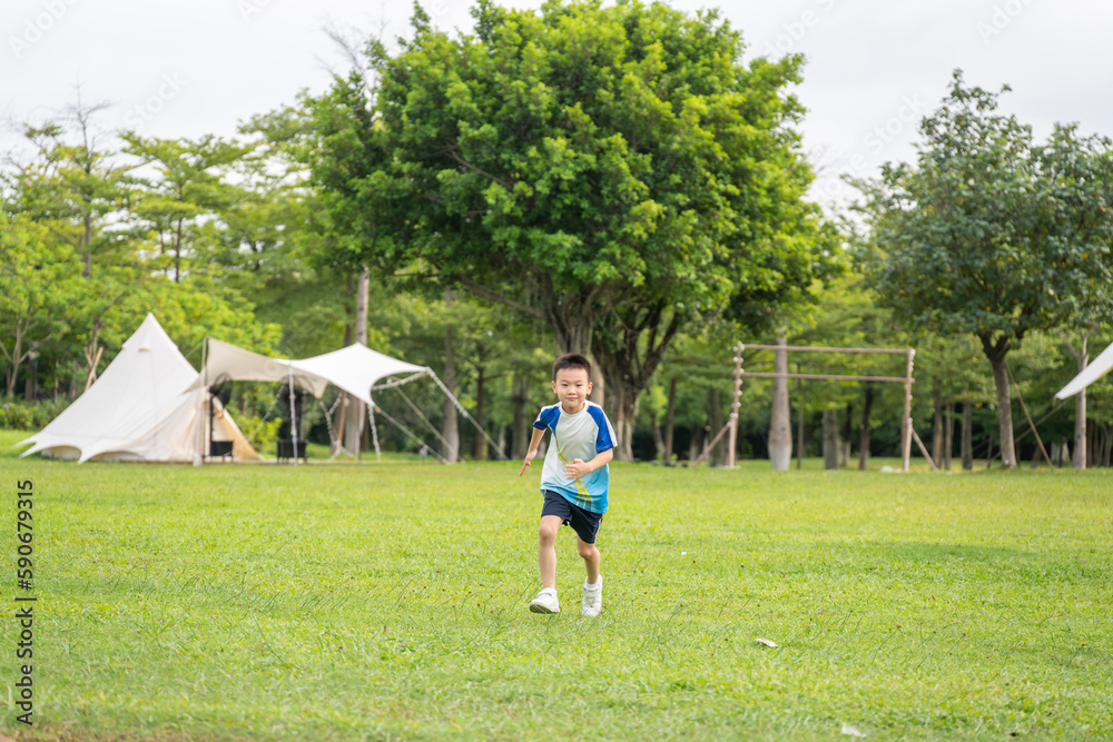 A boy running on the outdoor grass