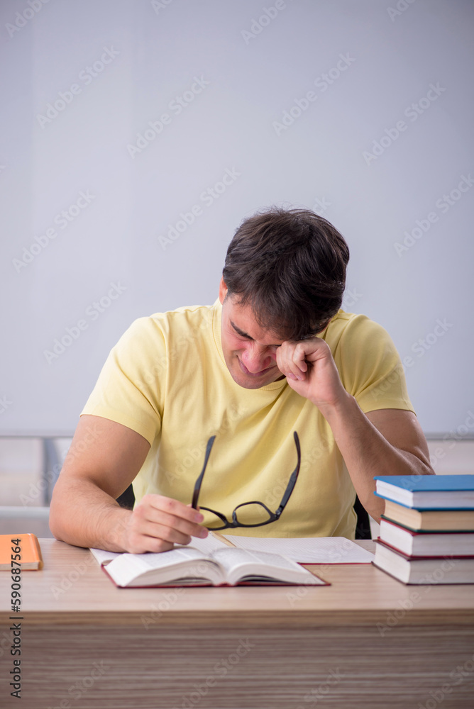 Young male student sitting in the classroom Young male student sitting in the classroom