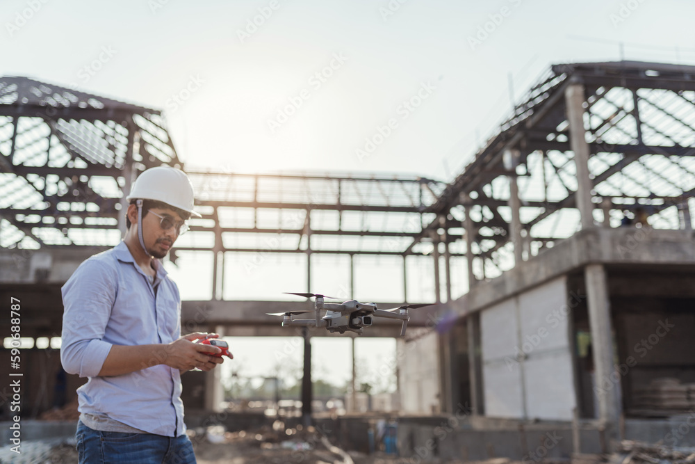 Architect operating drone for aerial view survey inspecting progress in construction. Asian man surveyor control drone for aerial view. Architect operating drone for aerial view survey inspecting progress in construction. Asian man surveyor control drone for aerial view.