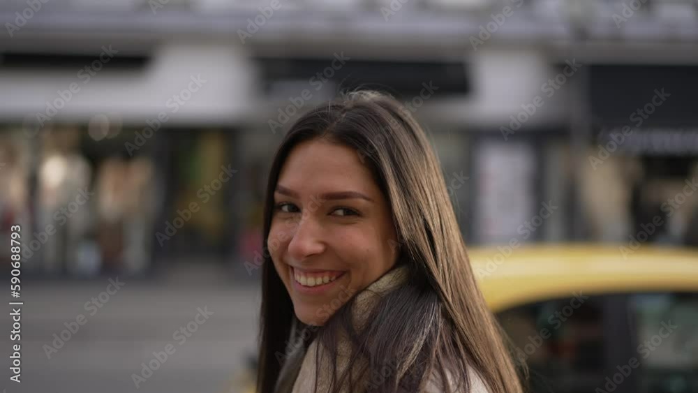 One happy young woman walks confidently in street sidewalk smiling. Closeup face of a joyful adult girl walking in urban environment One happy young woman walks confidently in street sidewalk smiling. Closeup face of a joyful adult girl walking in urban environment
