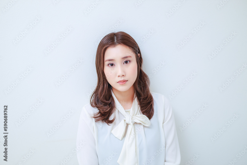 白いブラウスを着た真顔の若い女性 白いブラウスを着た真顔の若い女性
