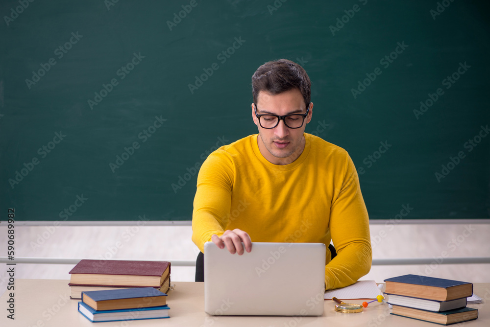 Young male student sitting in the classroom