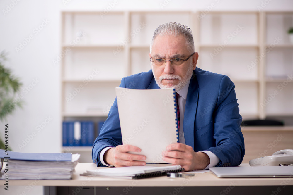 Old male employee and too much work at workplace Old male employee and too much work at workplace