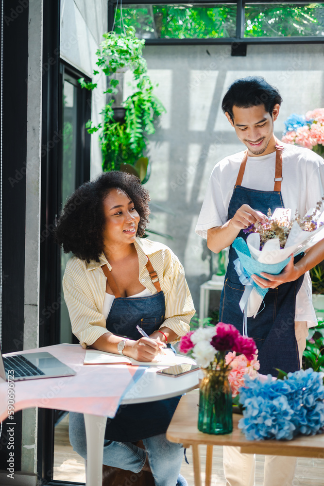 Asian male and African female florists flower store owners working and