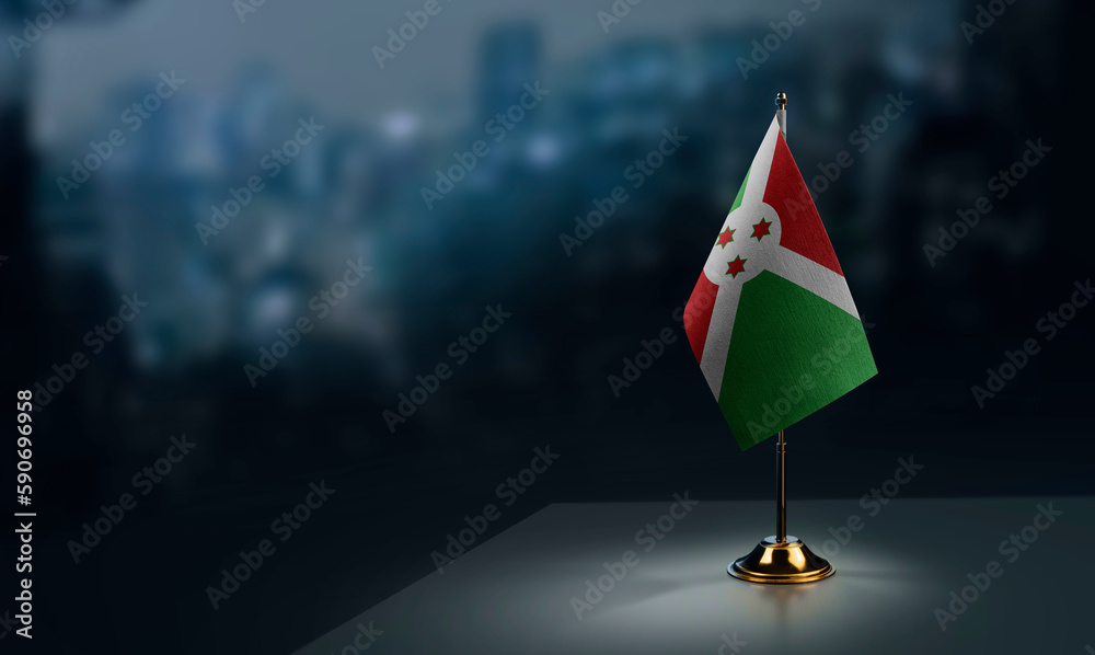 Small flags of the Burundi on an abstract blurry background
