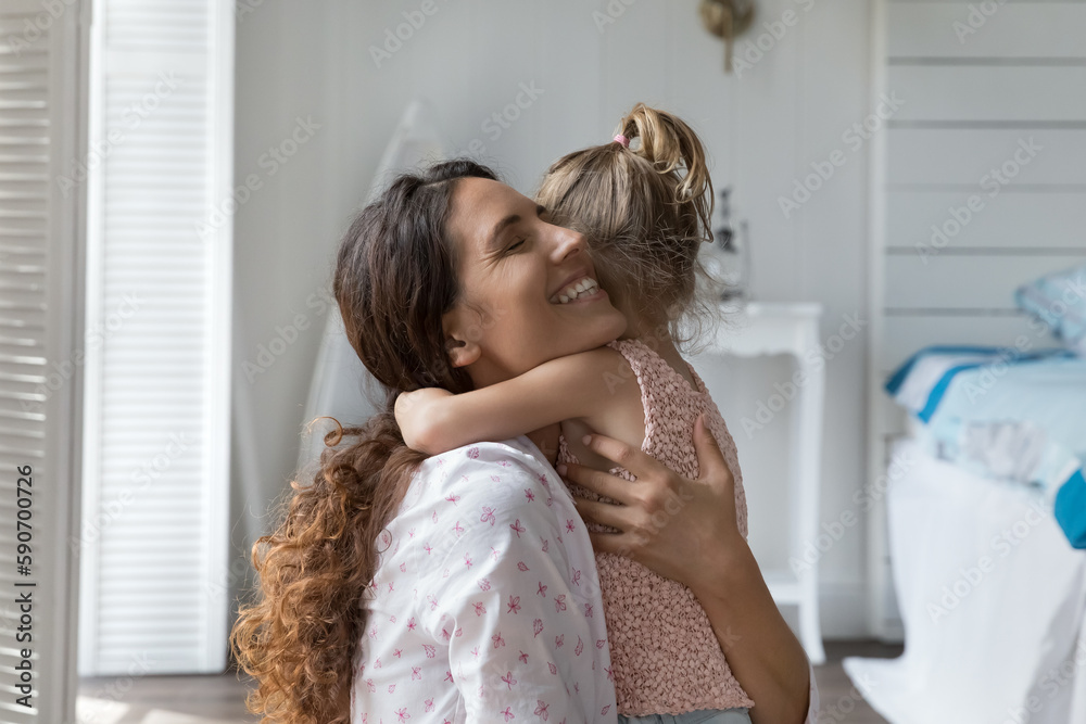 Happy loving mother hugging little kid with closed eyes, tightening daughter girl with affection, devotion, happiness, enjoying motherhood, close relations, bonding with child Happy loving mother hugging little kid with closed eyes, tightening daughter girl with affection, devotion, happiness, enjoying motherhood, close relations, bonding with child