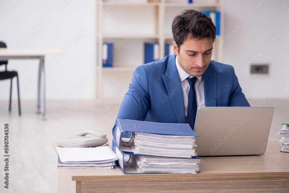 Fototapeta premium Young male employee and too much work in the office