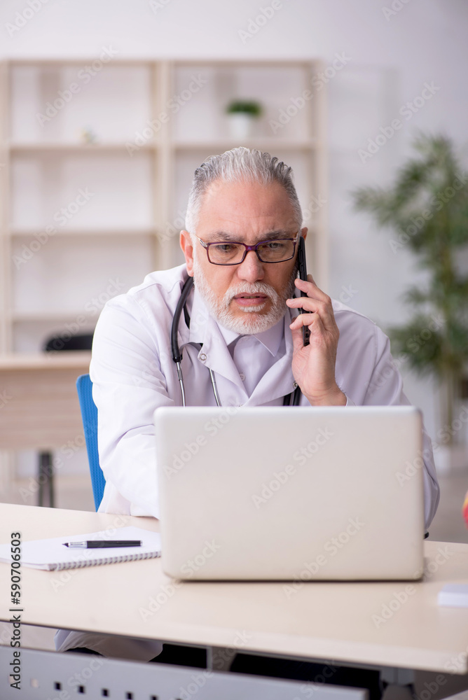 Old male doctor in telemedicine concept Old male doctor in telemedicine concept
