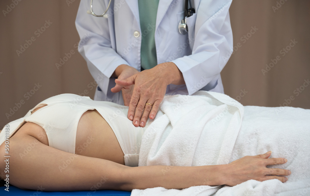 Female doctor use two hands to check up of woman abdomen patient in medical office Female doctor use two hands to check up of woman abdomen patient in medical office