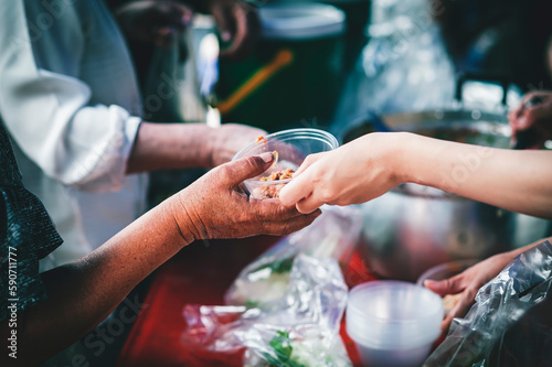 volunteer giving poor homeless bowl of food outdoors : food sharing ideas