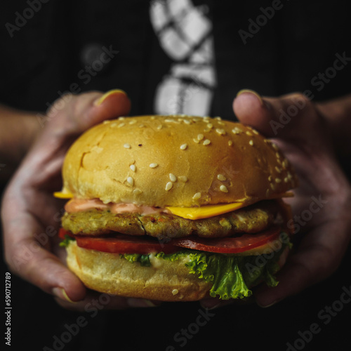 Hands holding fresh delicious burgers 