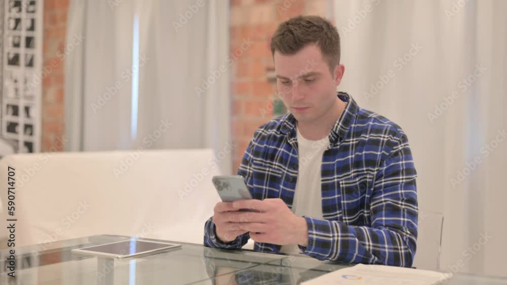 Young Casual Man Using Smartphone at Work Young Casual Man Using Smartphone at Work