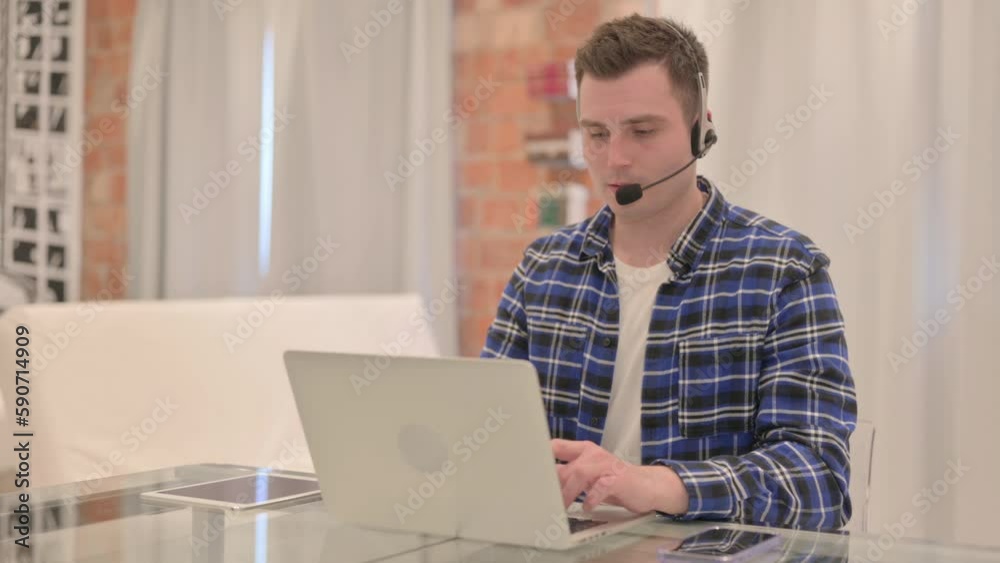 Young Casual Man with Headset Talking with Customers Online in Call Center Young Casual Man with Headset Talking with Customers Online in Call Center